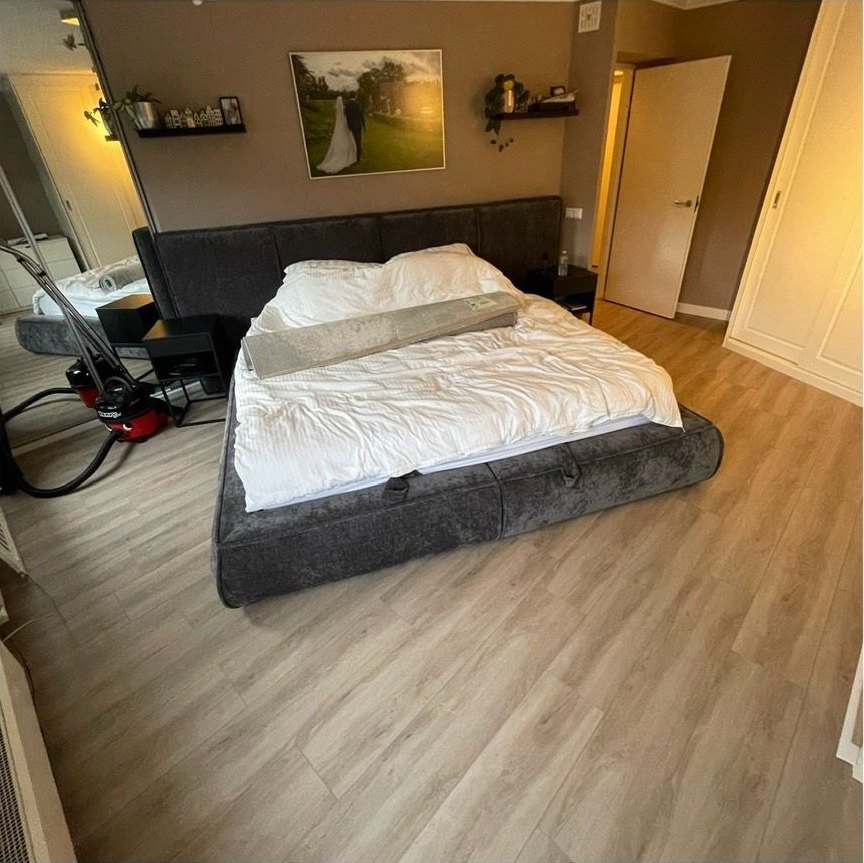 Slaapkamer met laminaat en TV